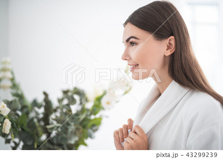 Satisfied woman keeping white bathrobe with arms Satisfied woman keeping white bathrobe with arms 43299239