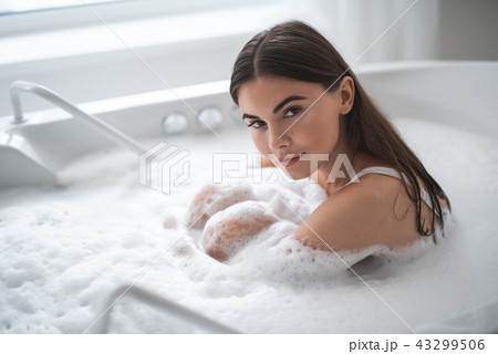 Calm woman resting in water with foam 43299506