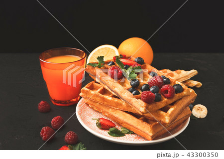 Belgian waffles with berries and fruits with juice glass 43300350