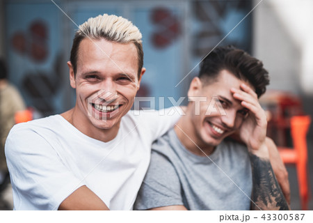 Cheerful men hugging and speaking together outdoor 43300587