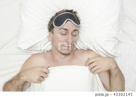 Man resting in mask for sleep. Stubble on face. Man resting in mask for sleep. Stubble on face. 43302145