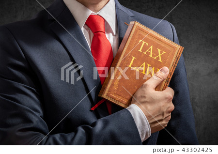 Lawyer stands with collection of tax regulations 43302425