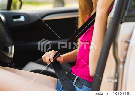 Picture of woman fasten seat belt in car Picture of woman fasten seat belt in car 43303186