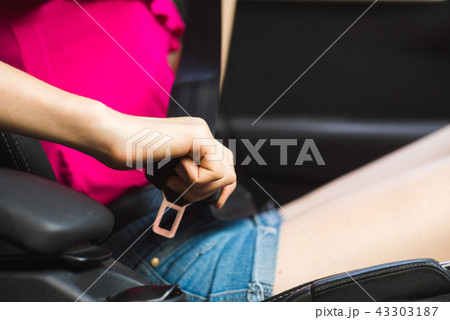 Female hand in car with seat belt 43303187
