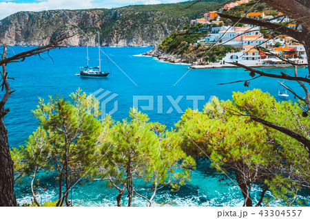 Beautiful sailing yacht near picturesque seacoast. Assos village Mediterranean Sea, Greece. Summer Beautiful sailing yacht near picturesque seacoast. Assos village Mediterranean Sea, Greece. Summer 43304557