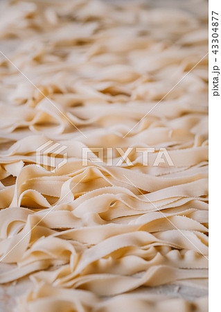 Raw Italian tagliatelle pasta background Raw Italian tagliatelle pasta background 43304877