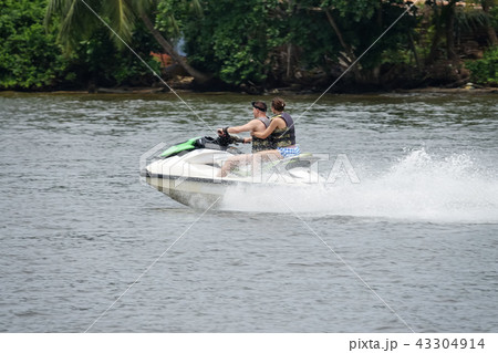 Happy young couple having fun riding on a jet ski 43304914