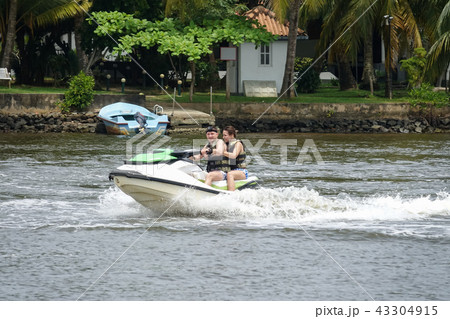 Happy young couple having fun riding on a jet ski 43304915