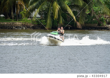 Happy young couple having fun riding on a jet ski 43304917