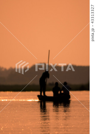 Blurred Men in a boat on a river silhouette 43313327