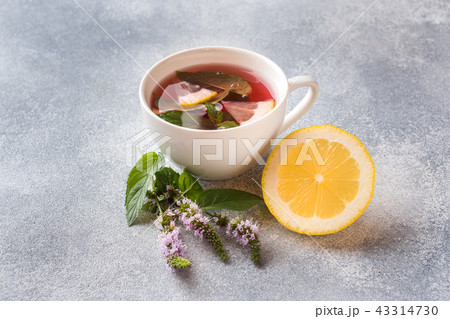 Cup of tea, mint and lemon on grey table  43314730