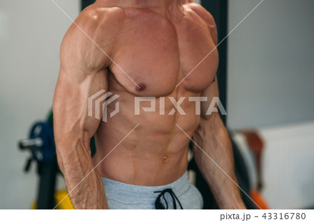 A young athlete trains in the gym. Trians biceps muscules A young athlete trains in the gym. Trians biceps muscules 43316780