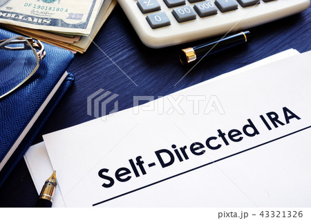 Self-Directed IRA SDIRA documents on a desk. 43321326