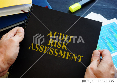 Man is holding Audit risk assessment report. 43321335