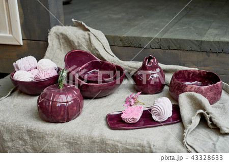 Set of handmade ceramics in purple on a piece of gray burlap.Rustic style. Clay modeling 43328633
