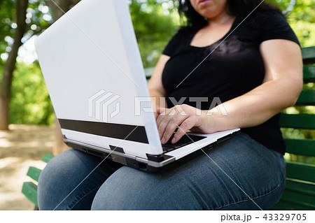 obese female worker with laptop working outdoors 43329705