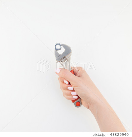 Female hand holding spanner on white background 43329940