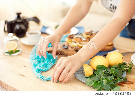 Close-up Female hands decorating sweet croissant on cooking table. 43333402