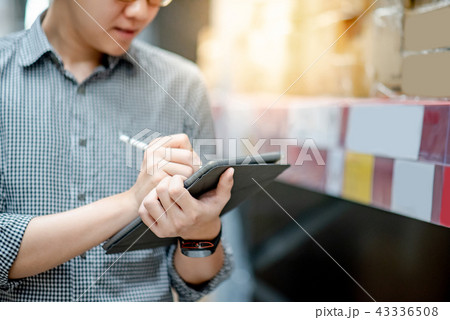 Asian man doing stocktaking on tablet in warehouse Asian man doing stocktaking on tablet in warehouse 43336508