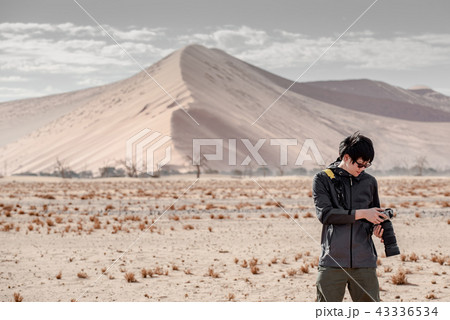 Male photographer taking photo in Namib desert 43336534