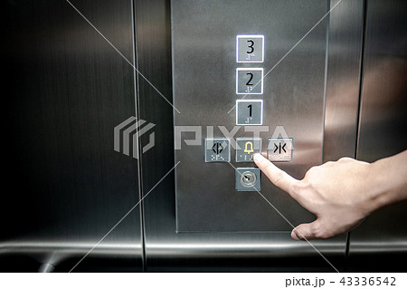 Male hand pressing on emergency button in elevator 43336542
