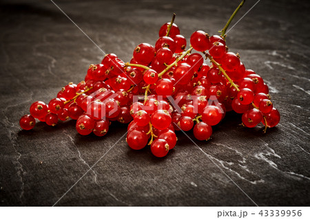 juicy red currant on an old black wooden table 43339956