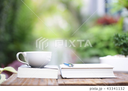 White coffee cup with notebooks on wooden table White coffee cup with notebooks on wooden table 43341132