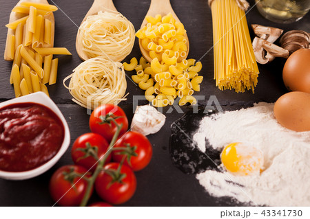 Four types of raw uncooked pasta next to tomatoe souce Four types of raw uncooked pasta next to tomatoe souce 43341730