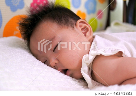 うつぶせ寝の生後2か月の赤ちゃん 女の子 の写真素材