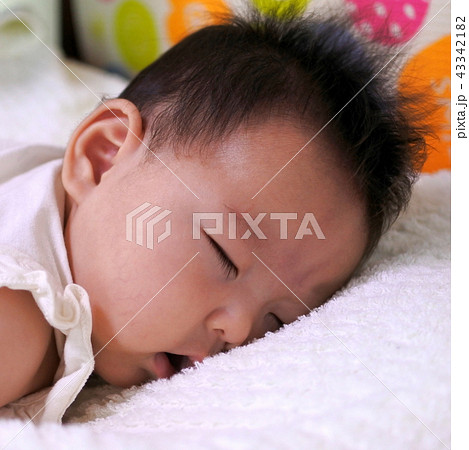うつぶせ寝の生後2か月の赤ちゃん 女の子 の写真素材