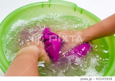 Photo on top of girl hands washing violet clothes in green basin Photo on top of girl hands washing violet clothes in green basin 43345938