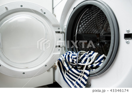Photo of open washing machine with striped cloth Photo of open washing machine with striped cloth 43346174