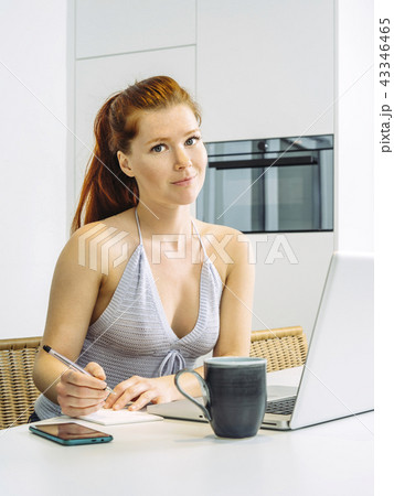 Working in the kitchen on her laptop Working in the kitchen on her laptop 43346465