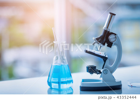 Microscope and Beaker on table in Laboratory. 43352444