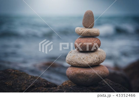 Stone tower on the rock near pebble beach. Stone tower on the rock near pebble beach. 43352466