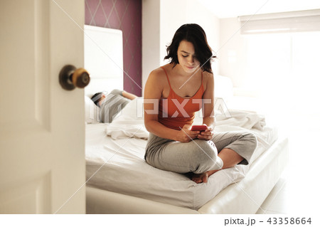 Woman Cheating Her Man Texting On Smartphone 43358664
