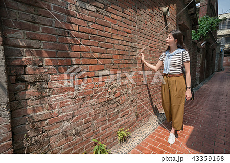 asian female walking in the old street. 43359168
