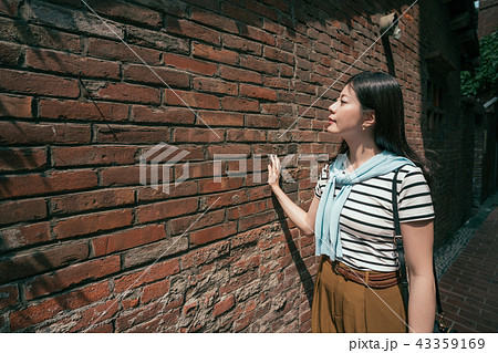 beautiful woman standing next to the wall. 43359169