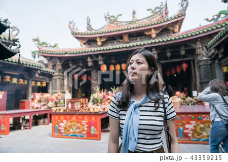 asian woman standing and looking around in the temple. 43359215
