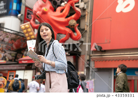 asian female holding a map and looking for a place. 43359331