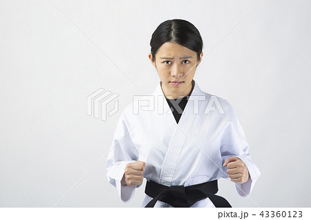 真剣な表情で拳を構える女性空手家の写真素材