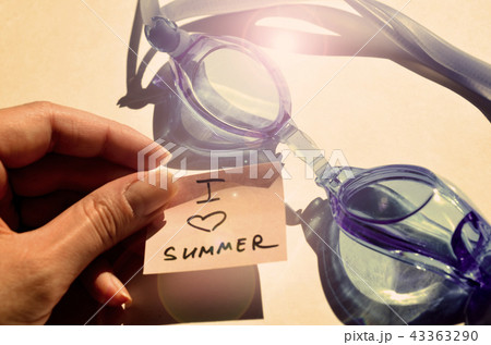 hand of a woman with fingers holds blue goggles 43363290