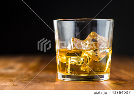 Glass of alcoholic drink with ice cubes. 43364037
