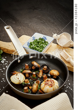 fried mushrooms on a hot pan on an old wooden table 43364180
