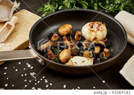 fried mushrooms on a hot pan on an old wooden table 43364181