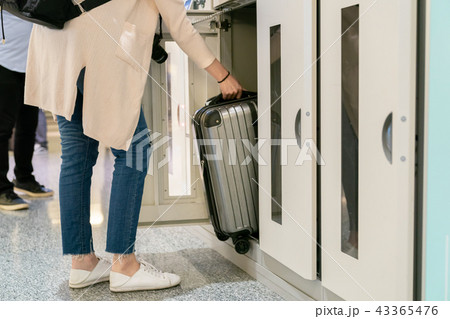 Putting the luggage in the locker. Putting the luggage in the locker. 43365476