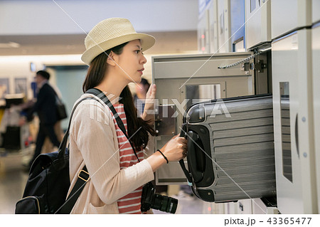 visitor putting the luggage in the locker. 43365477