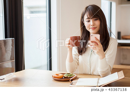 カフェで仕事をする若い女性の写真素材