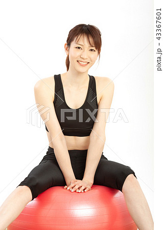 バランスボールで体幹トレーニングをする女性の写真素材