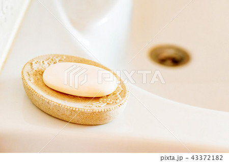 Soap on a dish over ceramic sink 43372182